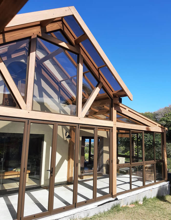 Pitched roof conservatory made out of aluminium, glass and wood