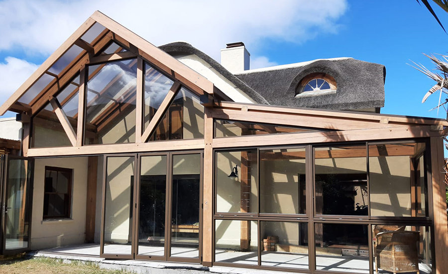 Front view of house with pitched roof conservatory made out of aluminium and wood